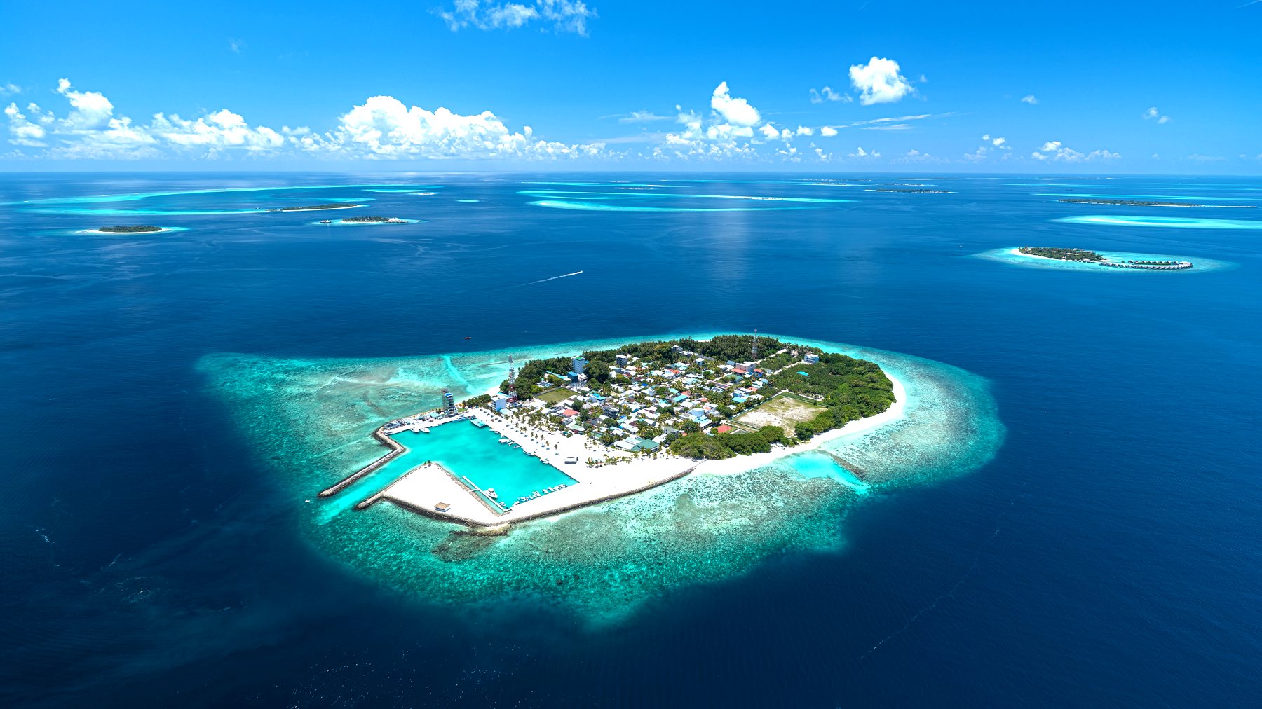 Kamadhoo Island from the air, ringed by turquoise reef
