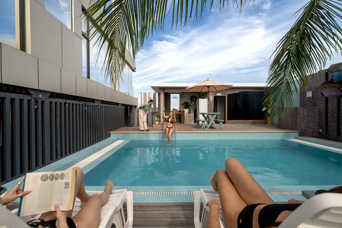 Guests reading on loungers by the hotel pool
