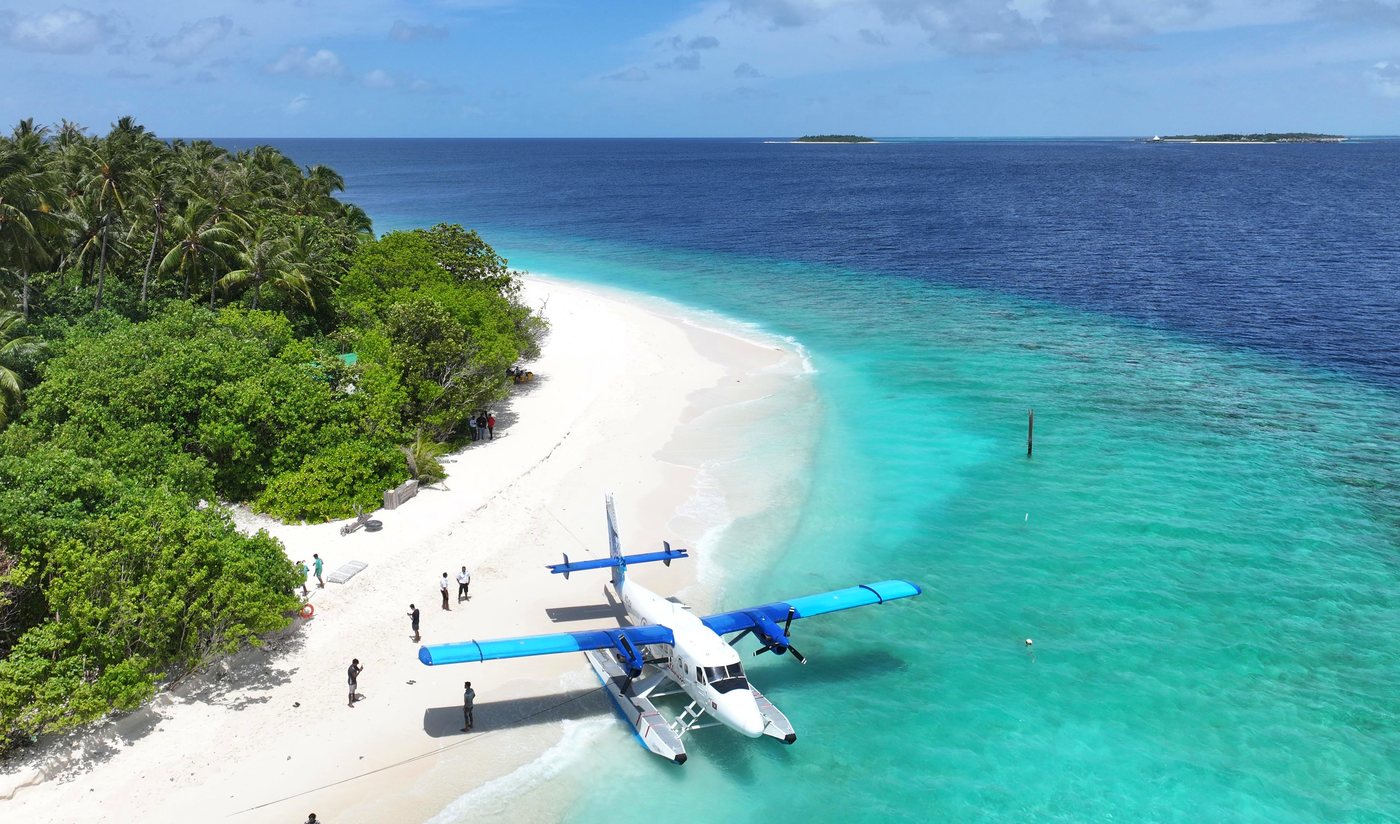 Seaplane pulled up on a white sand beach